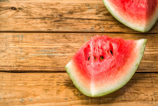 Slices of watermelon, background. Summer fruit on wooden planks background, close-up. - Fotografie, Obrázek