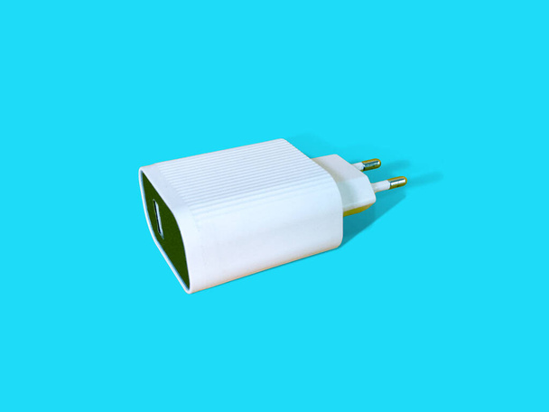 White Travel Charger Adapter isolated on bright turquoise color background. Back side, Corner angel view, lay down position - Photo, Image