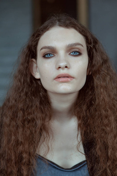 Mooi meisje met grote blauwe ogen en krullend haar - Foto, afbeelding
