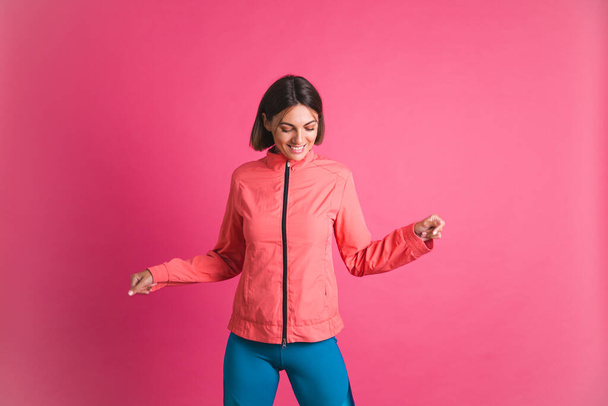 Young fit woman in sport wear jacket on pink background - Photo, Image