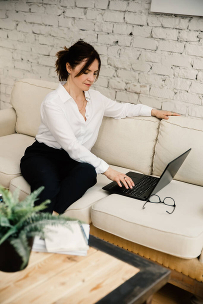 Mujer de mediana edad de negocios que trabaja en casa utilizando el ordenador portátil - Foto, imagen