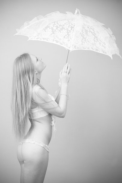 Portrait of a beautiful girl in a swimsuit with lace umbrella - Fotó, kép