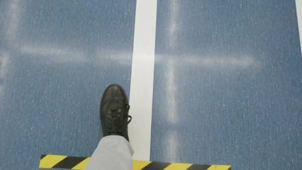 Hombre pies caminando en el suelo azul en el centro comercial. Líneas de unión para mantener la distancia. Primer plano. - Metraje, vídeo