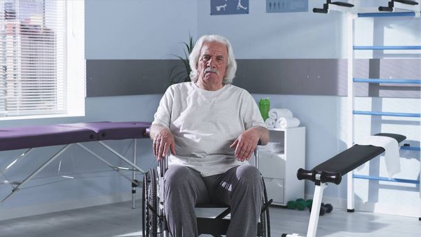 Старший человек на инвалидной коляске в реабилитационном центре - Фото, изображение