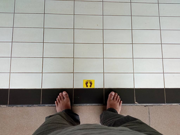 Someone standing on a safe distance sign inside a mosque - Photo, Image