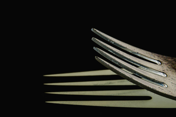 A closeup shot of a metal fork on a black background - Foto, Bild