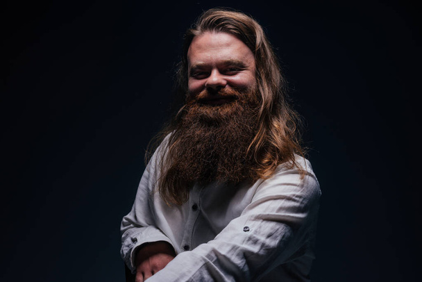 Közelkép portré jóképű férfi szakállas pózol stúdióban egy elszigetelt háttér. - Fotó, kép