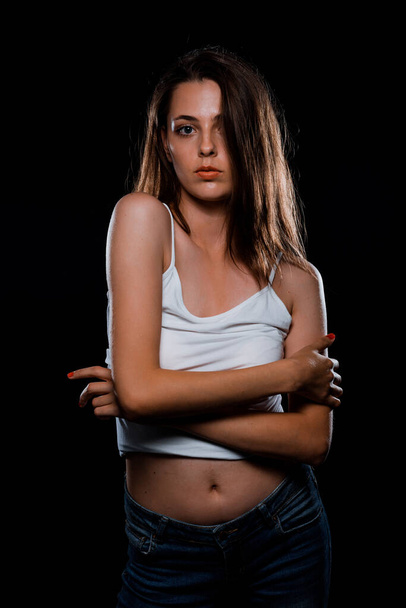 Body shot of a beauty modern girl wearing white top against black background - Photo, Image