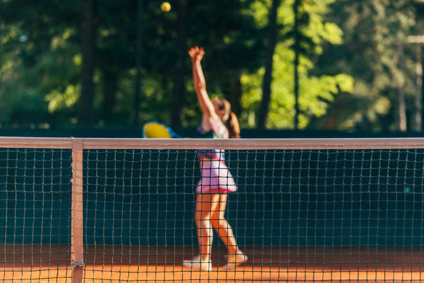 Hezká žena tenista pozorovaný přes síť. - Fotografie, Obrázek