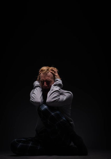 depressief en ongelukkig jongen zit en huilt zo hard terwijl schreeuwen de pijn uit hem - Foto, afbeelding