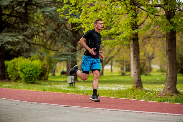 Sağlık ve Spor Bölümü. Koşu antrenmanında koşan bir sporcu. İnsanlar yaz aylarında birlikte koşu yaparak dışarıda sağlıklı ve aktif bir yaşam sürerler. - Fotoğraf, Görsel