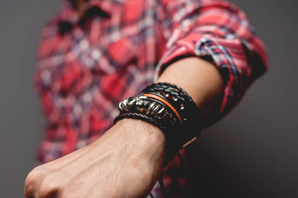 The man in red shirt wearing bracelets, casual style of men accessories. Shallow depth of field. - Foto, Imagem