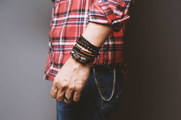 The man in red shirt wearing bracelets, casual style of men accessories. Shallow depth of field. - Photo, Image