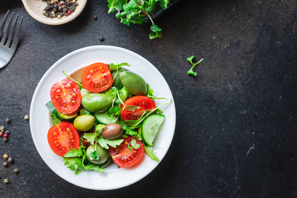 čerstvý salát s rukolou, rajčaty, cibulí a olivami. zdravé jídlo. - Fotografie, Obrázek