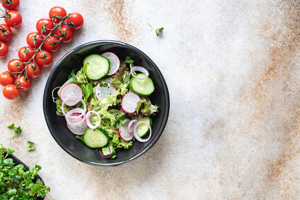 Salat mit frischem Gemüse und Rucola auf schwarzem Hintergrund  - Foto, Bild