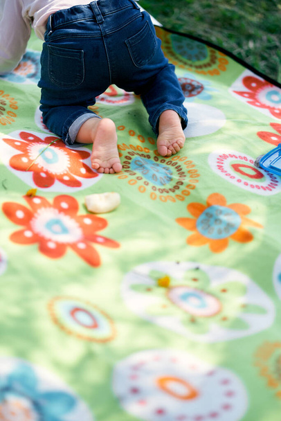La bambina sta strisciando su una coperta colorata. Primo piano - Foto, immagini