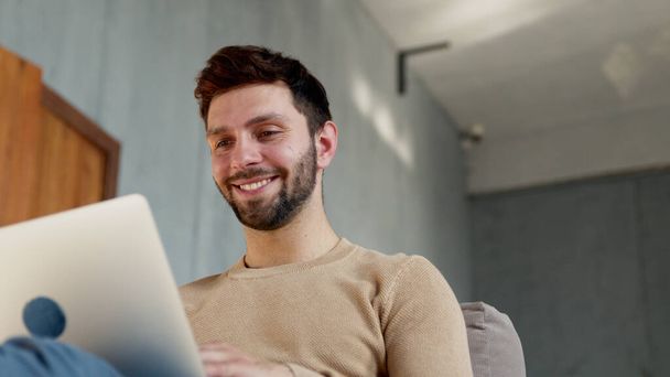 Счастливый человек с ноутбуком в квартире - Фото, изображение