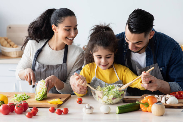 Prendre soin des parents arabes cuisiner avec leur petite fille dans la cuisine ensemble - Photo, image