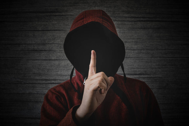 una persona desconocida sin rostro en una capucha muestra un gesto de dedo que significa pueblos. El concepto de anonimato y secreto en la red. - Foto, Imagen