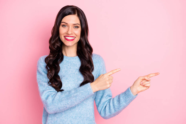 Photo of lovely girl indicate forefingers empty space wear blue sweater isolated pink color background - Fotoğraf, Görsel