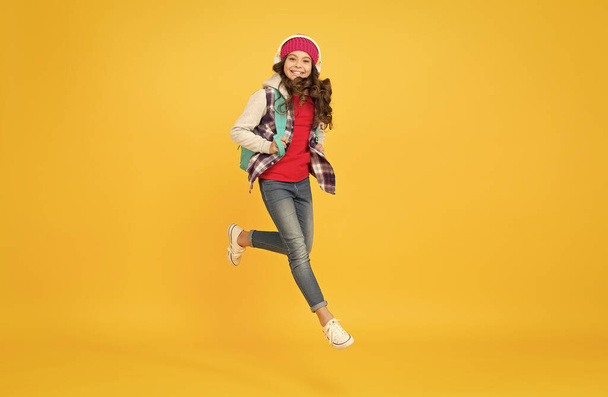 Life is a daring adventure. Happy child jump yellow background. Energetic girl wear backpack in casual style. Childhood adventure. Autumn vacation. Adventure fun. Enjoying playful day - Фото, зображення