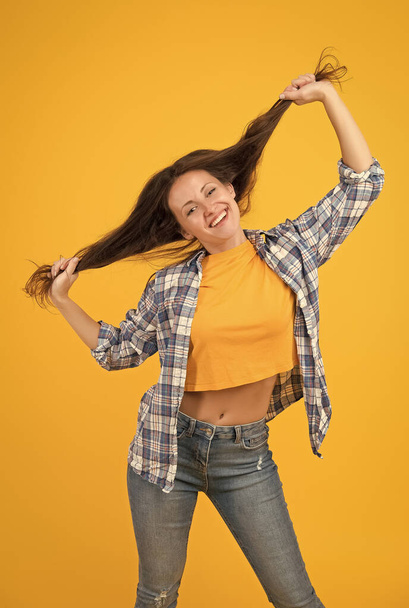 I always wanted to be a hairdresser. Happy woman hold long hair yellow background. Beauty salon. Salon haircare. Shampooing and conditioning. Tangle free care - Φωτογραφία, εικόνα