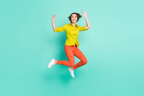 Full length body size photo of jumping high woman waving hands greeting cheerful isolated bright turquoise color background - Foto, imagen