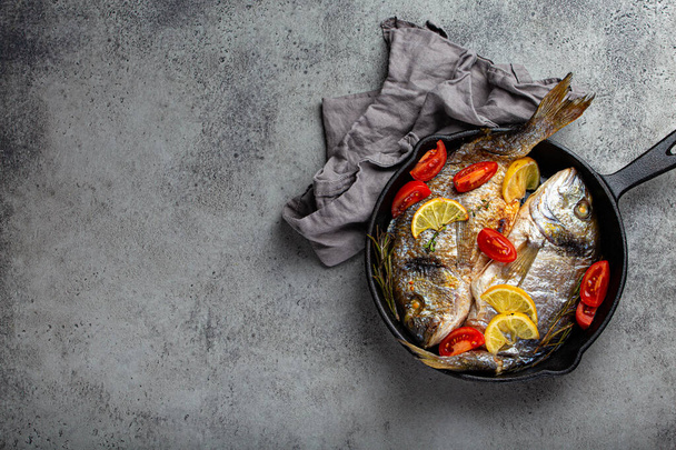 Grilled fish sea bream or dorado in cast iron skillet copy space - Fotografie, Obrázek