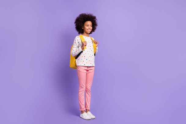 Full size photo of dark skin girl look copyspace wear pink pants backpack isolated on violet color background - Foto, Imagen