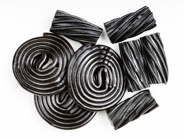 mehrere schwarze Süßholzbonbons in Nahaufnahme auf weißem Teller - Foto, Bild
