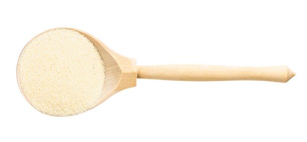 vrchní pohled na dřevo lžíce s tepelně neupravené měkké pšenice manna krupice izolované na bílém pozadí - Fotografie, Obrázek