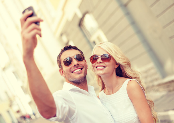 smiling couple with smartphone in the city - Photo, Image