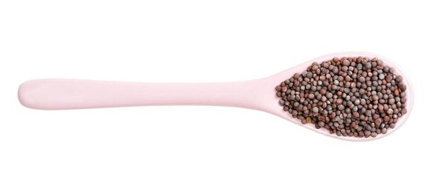 вид сверху керамической ложки с семенами черной горчицы на белом фоне - Фото, изображение