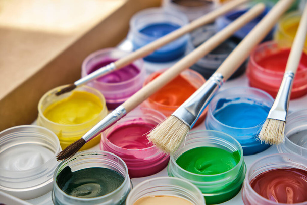 Nahaufnahme von Acrylfarben, Farbpalette und Pinsel. Neues Set von 24 Farben für die Malerei. Kreativität, Hobby-Konzept - Foto, Bild