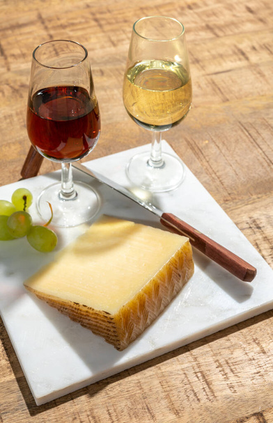 Peynir koleksiyonu, La Mancha bölgesinde koyun sütünden yapılmış bir parça manchego peyniri ve açık havada servis edilen bir bardak şeri şarabı. - Fotoğraf, Görsel