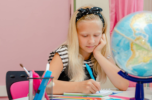 Sarışın beyaz kız evde ders çalışıyor. Eğitim ve öğrenme kavramı - Fotoğraf, Görsel