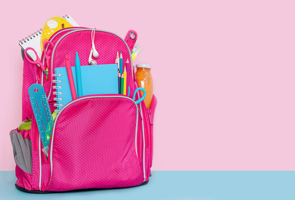 Backpack with school supplies standing on pink background. - Photo, Image