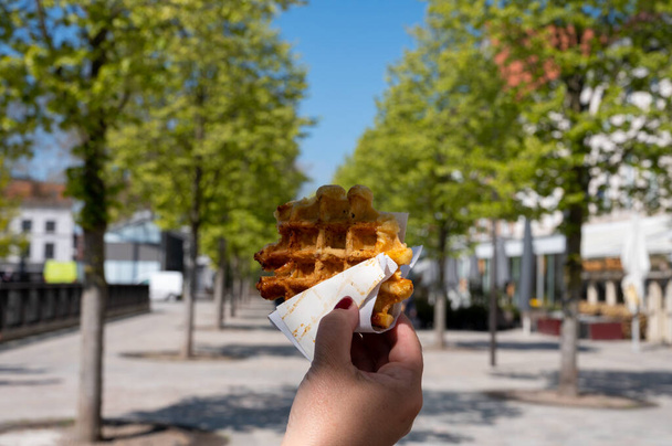 Mangiare waffle di zucchero belgi caldi appena sfornati, street food a Bruges - Foto, immagini