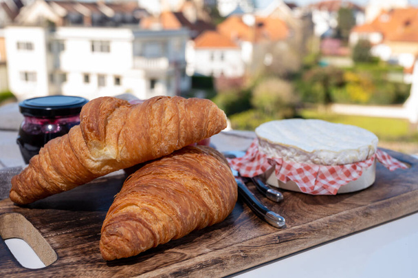 Ranskalainen aamiainen tuoreilla paistetuilla croissanteilla ja juustoilla Normandiasta, camembert ja neufchatel palvelivat ulkona mukavalla ranskalaisella kylällä. - Valokuva, kuva