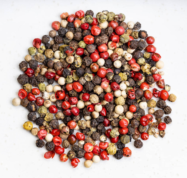 top view of pile of Four Pepper Blend peppercorns close up on gray ceramic plate - Photo, Image