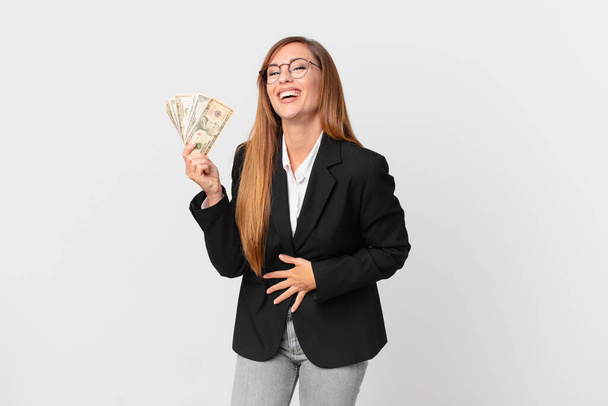 pretty woman laughing out loud at some hilarious joke. business and dollars concept - Фото, изображение