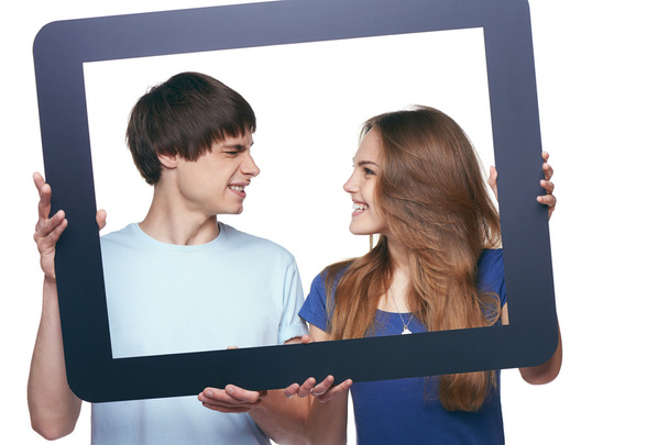 Happy couple holding tablet frame and looking at each other - Foto, immagini