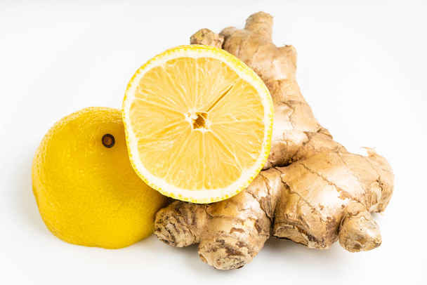 natural fresh whole ginger root and halved lemon fruit on gray plate close up - Φωτογραφία, εικόνα
