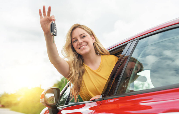 Attractive young woman shows the keys to the car. - Foto, afbeelding