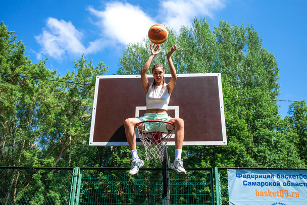 Young beautiful brunette girl posing on the basketball court - Foto, imagen
