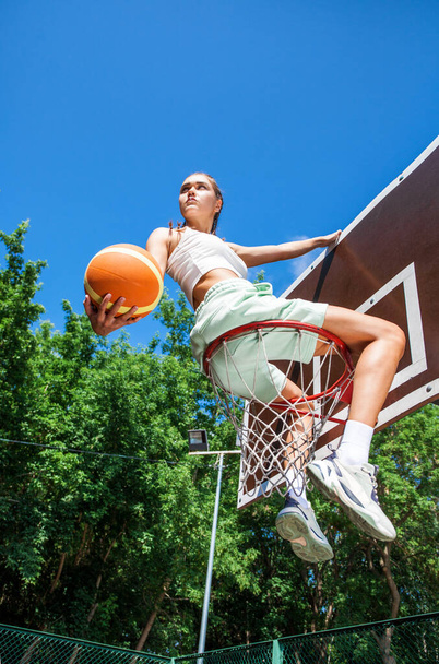 Young beautiful brunette girl posing on the basketball court - Foto, Imagem