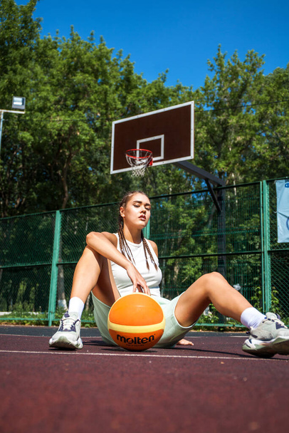 Young beautiful brunette girl posing on the basketball court - Photo, Image
