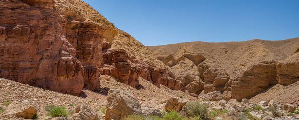 Rocce sedimentarie rosse accanto a formazioni calcaree nel Red Canyon, vicino a Eilat, Israele, in una giornata limpida e soleggiata. - Foto, immagini