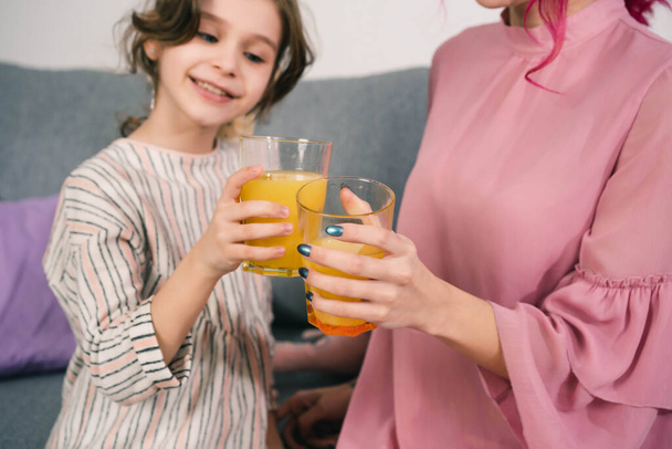 girls enjoy drinking delicious orange juice in the company of a photographer - Foto, imagen