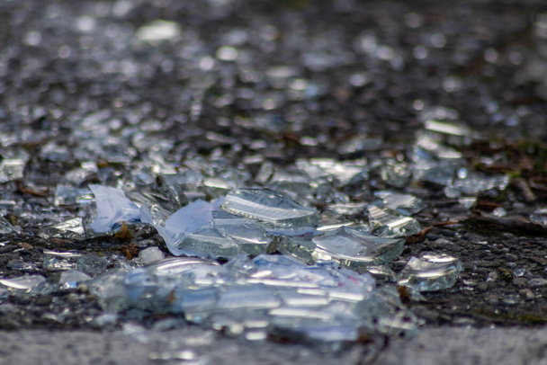 Ostré střepy rozbité skleněné láhve na zemi s ostrými čepelemi jsou nebezpečné od vandalismu a opilých lidí ukazujících křehkou láhev a rozbitý nápoj drcený jako odpad z recyklace zbraní - Fotografie, Obrázek
